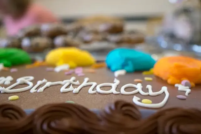 A chocolate birthday cake decorated with coloured icing.