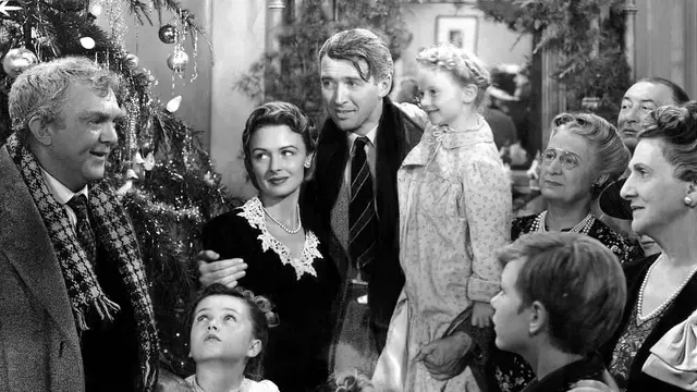 A black-and-white picture of a family gathered around a Christmas tree.
