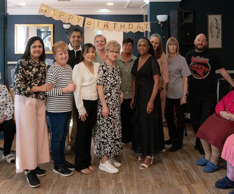 The Aria Care Home team, gathered together under birthday bunting