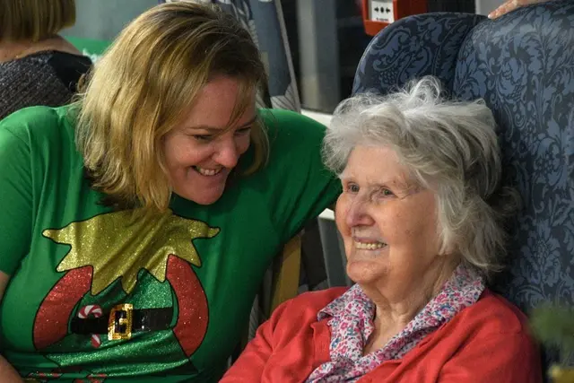 A member of the team sharing a laugh with a resident at Christmas
