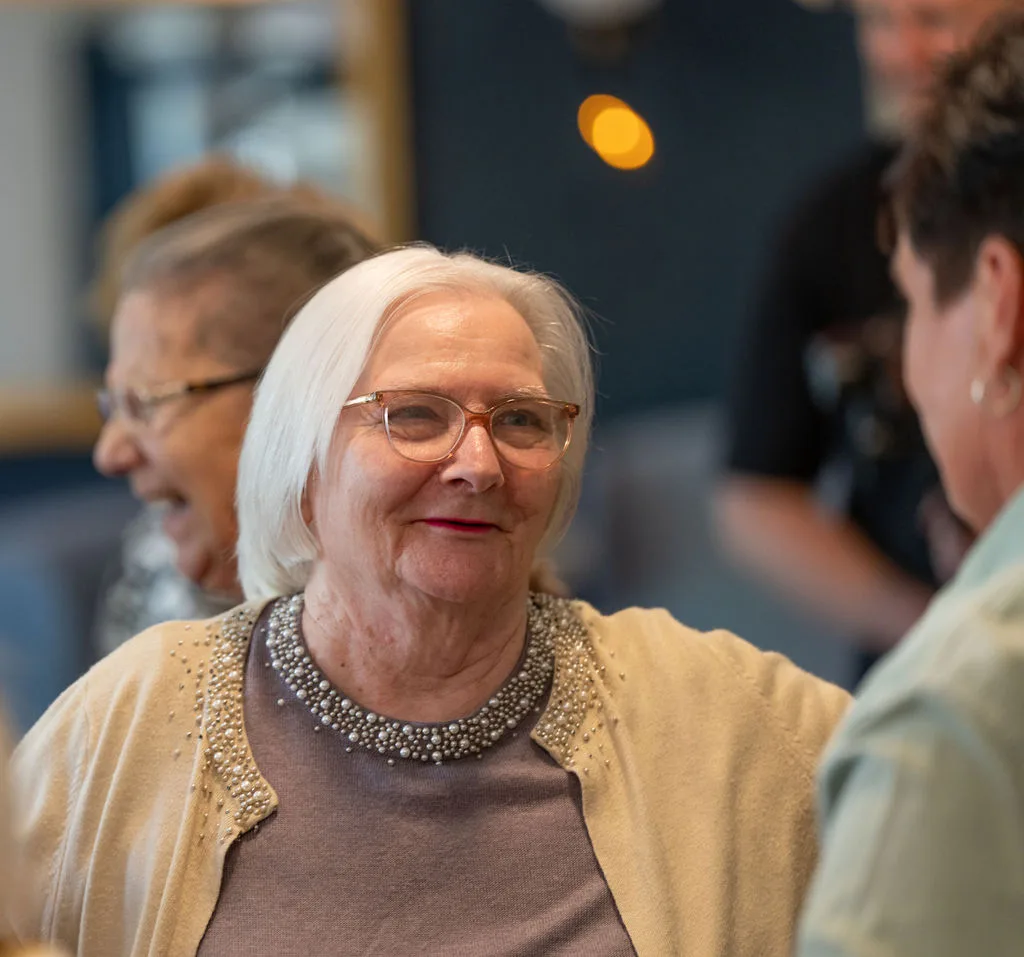 A resident smiling in conversation at Aria Care Home, Newport